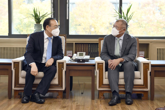 Euisun Chung, Hyundai Motor Group chairman, right, and Oh Se-jung, Seoul National University president, converse at the president’s office in Gwanak District, southern Seoul, on Wednesday. The leading Korean automotive group and Korea’s top university have signed an agreement to establish a joint research center on batteries. Hyundai Motor said it will be investing a minimum of 30 billion won ($25 million) in the next 10 years on the joint research and development. [HYUNDAI MOTOR GROUP]
