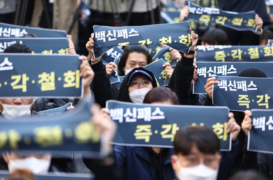 Owners of indoor gyms demanding that the government and the ruling Democratic Party lift obligatory vaccine passes protest in front of the DP’s headquarters in Yeouido, Seoul, on Wednesday. Since Nov. 1, the government’s social distancing regulations have been eased, including no restrictions on business hours for cafes and restaurants and allowing up to 10 people to congregate. Several business types, including indoor gyms, noraebang and public bathhouses, still face restrictions. To use these venues, customers have to have a vaccine pass that verifies that they have been fully vaccinated. [YONHAP]
