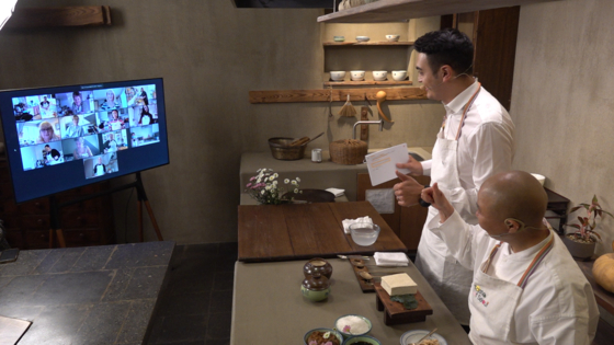 Jeong Kwan, right, interacts with participants from the Korea Culture Centre UK joining via Zoom during a temple food cooking class on Wednesday, which was held as part of the "2021 Taste of Seoul Week." [SEOUL TOURISM ORGANIZATION]