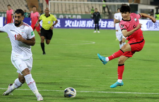 Hwang In-beom, right, shoots with his left foot in a match against Iran at Azadi Stadium in Tehran, Iran in the qualifiers for the 2022 Qatar World Cup on Oct.12. [YONHAP]