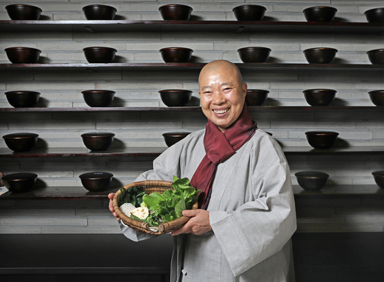 Jeong Kwan poses for a photo during an interview with the Korea JoongAng Daily at her restaurant Doosoogobang in Suwon, Gyeonggi, on Wednesday. Behind her are shelves with baru, or bowls used by Buddhist monks. [PARK SANG-MOON]