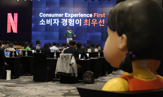 A doll from the popular Netflix original series ″Squid Game″ is set up at the back of the hall during the press conference held on Thursday at central Seoul. [YONHAP]