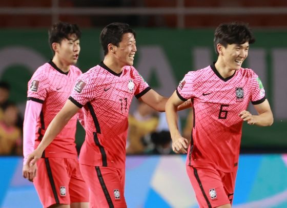 Hwang In-beom, right, celebrates with Hwang Hee-chan, center, and Son heung-min after scoring Korea's first goal against Syria in the third round of qualifiers for the 2022 Qatar World Cup at Ansan Wa Stadium in Ansan, Gyeonggi on Oct. 7. [NEWS1]