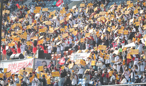 LG Twins fans cheer on their team during the third game of the first round of the 2021 KBO playoffs against the Doosan Bears at Jamsil Baseball Stadium in southern Seoul on Sunday. [YONHAP]