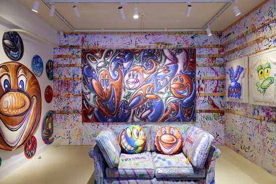 A replica of Kenny Scharf's art studio in LA features his actual sofa. The brushstrokes on the wall and sofa are no accident - Scharf really paints on them while working on his art. [BAIK ART]