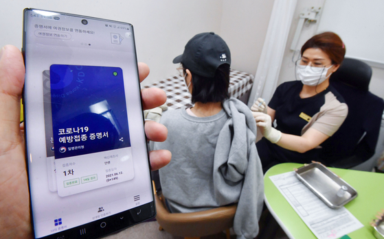 A woman receives a Covid-19 booster shot at a medical clinic in Yangcheon District, western Seoul, on Monday, as booster shots for those who have taken Johnson & Johnson's Janssen vaccine at least two months ago became available starting that day. [YONHAP]