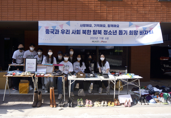 High school students from Seoul International School hold a bazaar Saturday to help young North Korean defectors settle in China or South Korea. A group of students, named Peace by Piece, has been raising funds for young defectors through the annual bazaar since 2017. [PEACE BY PIECE]