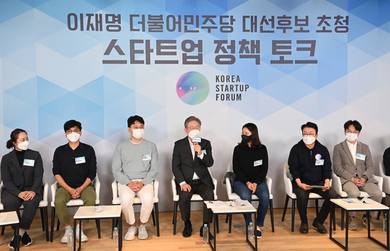 Democratic Party presidential candidate Lee Jae-myung sits down with the CEOs of local start-ups including Zigbang, Kurly, Dunamu, Watcha, Viva Republica and 8percent on Monday in eastern Seoul. [JOINT PRESS CORPS]
