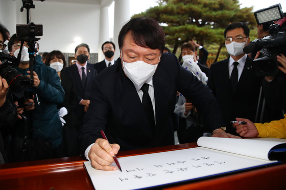 Yoon Seok-youl, the presidential candidate for the main opposition People Power Party (PPP), signs the guest book at the Seoul National Cemetery in Dongjak District, southern Seoul, Monday morning as his first official activity as the PPP’s presidential candidate. He wrote: “I will open an era of national victory by upholding the will of the ancestors.” [NEWS1]
