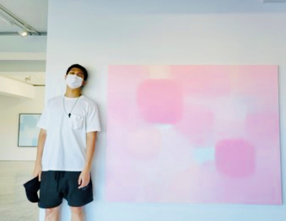 BTS's RM stands beside a painting by artist Suh Seung-won at PKM Gallery in September. [BTS OFFICIAL TWITTER]