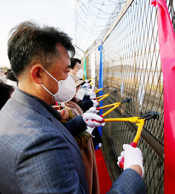 Citizens of Gimpo, Gyeonggi, cut wire fences which had been set up by the military decades ago to ward off North Korean infiltration along the Han River near the demilitarized zone at a ceremony to remove the wire fences on Wednesday. [YONHAP]