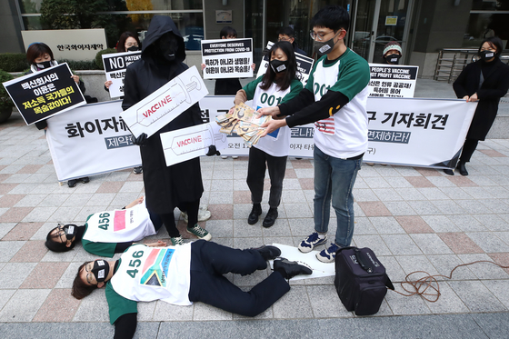 Members of health-related civic groups stage a demonstration in front of Pfizer's Seoul headquarters in Jung District, central Seoul on Wednesday, claiming that the American pharmaceutical company has imposed unfair terms in their Covid-19 vaccine supply deals in order to maximize profit while minimizing risk related to side effects. [YONHAP]
