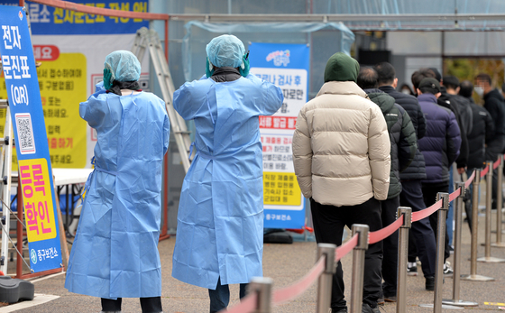 Medical staff at a Covid-19 testing site in a public health center in Daejeon use portable heat packs to warm themselves on Wednesday. [KIM SEONG-TAE]