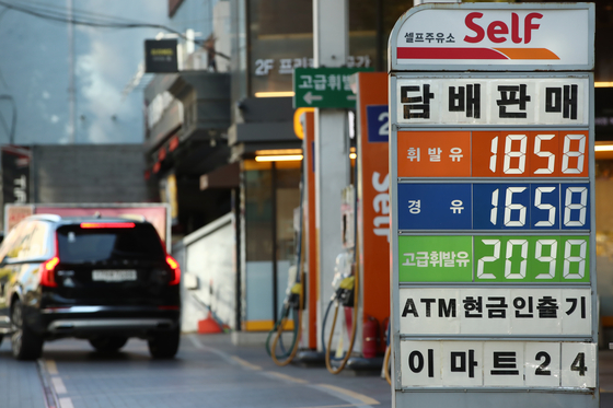 A car leaves a gas station in Seoul on Thursday. Fuel taxes will be cut by 20 percent over the next six months starting Friday. The total amount of tax on a liter of gasoline will fall from the current 820 won (70 cents) to 656 won. [YONHAP] 