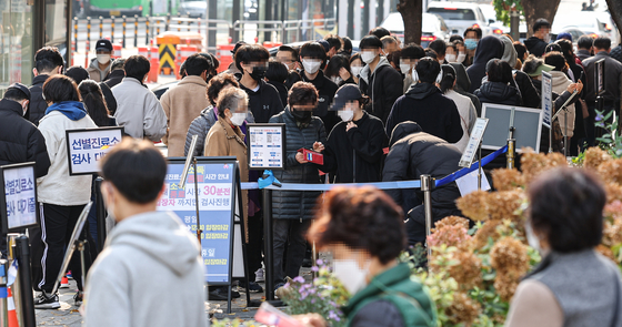 A Covid-19 testing site at a public health center in Songpa District, southern Seoul, is crowded with people trying to receive a virus test on Sunday morning. [YONHAP]