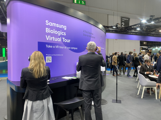 Visitors participate in a virtual reality program to look at Samsung Biologics’ third manufacturing plant in the company’s booth at CPhI Worldwide 2021 Tuesday. [SARAH CHEA]