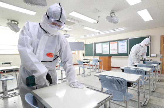 Quarantine workers disinfect a classroom for the state-administrated college entrance test in Dongtan High School in Hwaseong, Gyeonggi, on Tuesday, two days before the test will be taken by 509,821 students nationwide. [NEWS1]