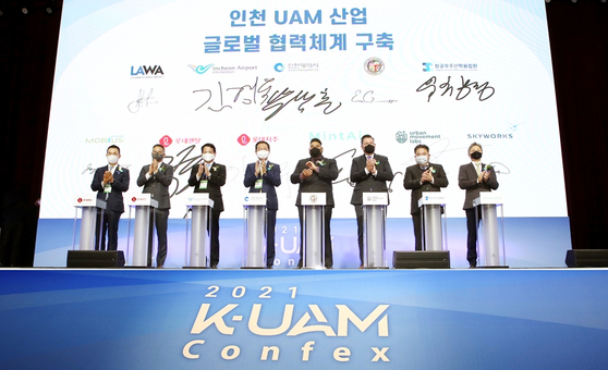 From left: Lotte Rental CEO Kim Hyun-soo, Lotte Corporation Managing Director Kim Seung-wook, Incheon International Airport Corporation President Kim Kyung-wook and Incheon Mayor Park Nam-choon pose after signing a partnership agreement at the 2021 K-UAM Confex held in Yeongjongdo, Incheon, on Tuesday. Also in the photo are, second from right, Institute for Aerospace Industry-Academia Collaboration President Ryoo Chang-kyung and, far right, MintAir CEO Choi Eugene. [LOTTE RENTAL]