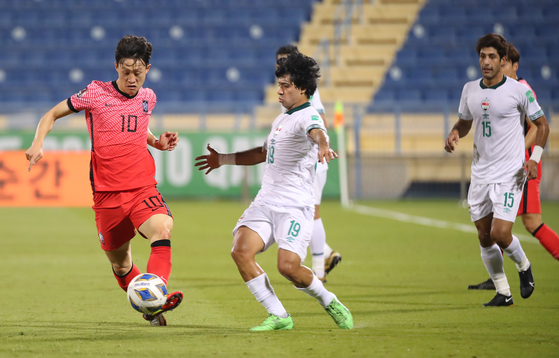 Lee Jae-sung, left, plays the ball at the second leg of the third round of Asian qualifiers for the 2022 Qatar World Cup against Iraq at Thani bin Jassim Stadium in Doha, Qatar, on Tuesday. [YONHAP]