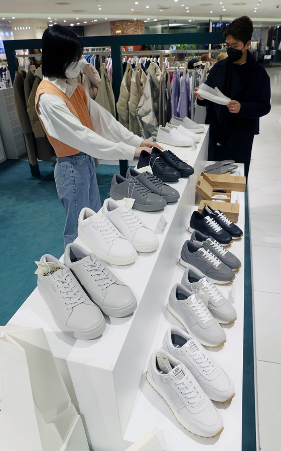 Visitors look at sneakers at the LAR store that opened in Lotte Department Store's Jamsil branch in Songpa District, southern Seoul, on Thursday. The new store will sell various sneakers by the brand, which are made out of recycled plastic. [YONHAP]