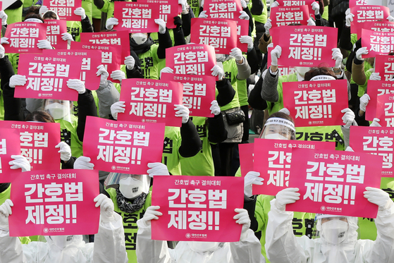Members from the Korean Nurses Association call for the establishment of a nursing law during a resolution rally held in front of the National Assembly in Yeouido, western Seoul, on Tuesday, one day before the National Assembly's first deliberation on the law. [NEWS1]