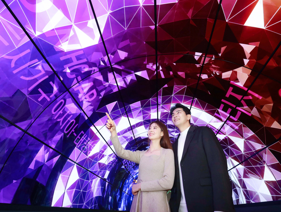 Models pose inside a 10-meter (33-foot)-long tunnel made of 55-inch OLED flexible displays by LG Electronics. LG Electronics installed its flexible displays and transparent OLED displays at the Salon Heritage, which showcases Unesco World Heritages, in Gyeongju, North Gyeongsang. The event hall was opened on Nov. 14. [LG ELECTRONICS]