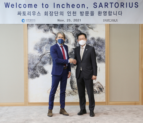 Joachim Kreuzburg, left, CEO of German-based biotech company Sartorius, poses with Incheon mayor Park Nam-choon after a meeting at the G-Tower in Yeonsu District, Incheon, on Thursday. The meeting was held to discuss the $300 million investment pledge made in November for Sartorius to build a biopharmaceutical raw material plant in Songdo, Incheon. The plant will manufacture cell culture media, membrane filters and other raw materials. [INCHEON FREE ECONOMIC ZONE]