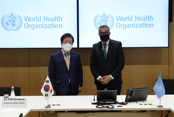 Korean National Assembly Speaker Park Byeong-seug, left, and World Health Organization (WHO) Director General Tedros Adhanom Ghebreyesus pose for a photo at the WHO headquarters in Geneva, Switzerland, Tuesday, ahead of talks on vaccine cooperation. [NATIONAL ASSEMBLY SPEAKER’S OFFICE]