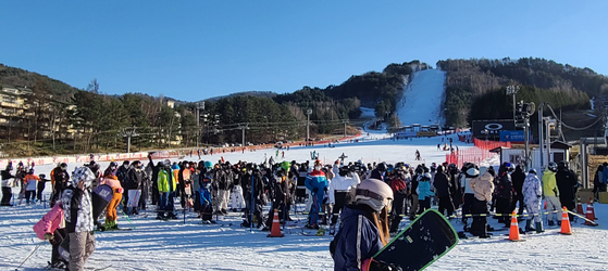 Skiers and snowboarders line up at a lift stop in Yongpyeong Ski Resort in Pyeongchang County, Gangwon, on Saturday, the first weekend the resort has opened the ski slope for the season. [YONHAP]
