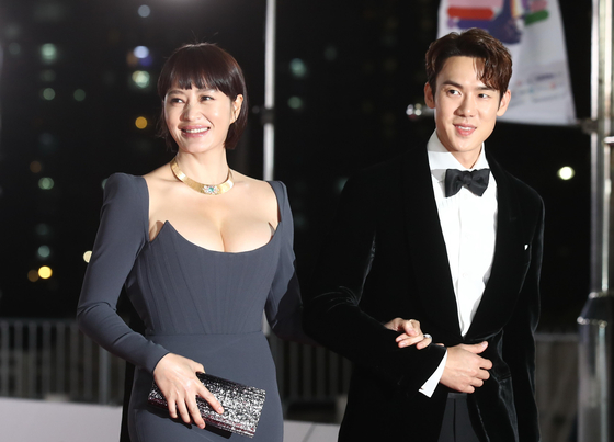 Actors Kim Hye-soo, left, and Yoo Yeon-seok, hosts of the 42nd annual Blue Dragon Film Awards, walk the red carpet for the awards ceremony held at KBS Hall in western Seoul on Friday night. [YONHAP] 