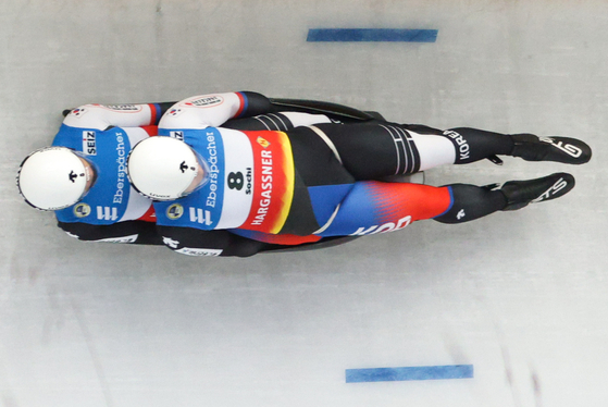 Korean lugers Cho Jung-myung, left, and Park Jin-yong compete in a men's doubles event during a 2021-22 FIL Luge World Cup stage, at the Sanki Sliding Centre in Rzhanaya Polyana, Russia on Saturday. The team finished 13th out of 22 teams with a time of 1:41.515. [TASS/YONHAP]