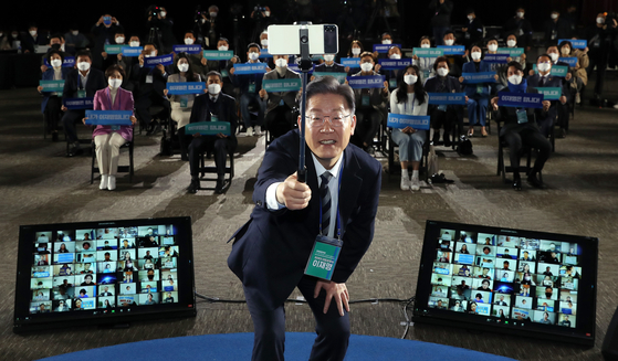 Ruling Democratic Party presidential candidate Lee Jae-myung poses for a selfie with the crowd Monday after holding a town hall with 200 people participating virtually and in-person at the Kim Dae-jung Convention Center in Gwangju, to mark 100 days till the election. [NEWS1] 