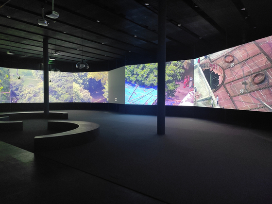 In “Moving Panorama,” a 360-degree dark room has been filled with eight large-format screens to create a virtual tour of cities across the globe including Mumbai, Manchester, Jerusalem and Kabul. [NAM JUNE PAIK ART CENTER]