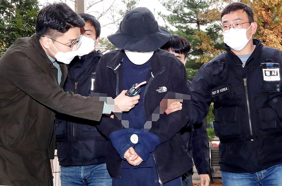 The 48-year-old man who allegedly attacked his downstairs neighbors with a knife after police officers came to his residence to investigate a noise complaint they had filed against him is escorted to his arrest warrant review at the Incheon District Court on Nov. 17. [YONHAP]