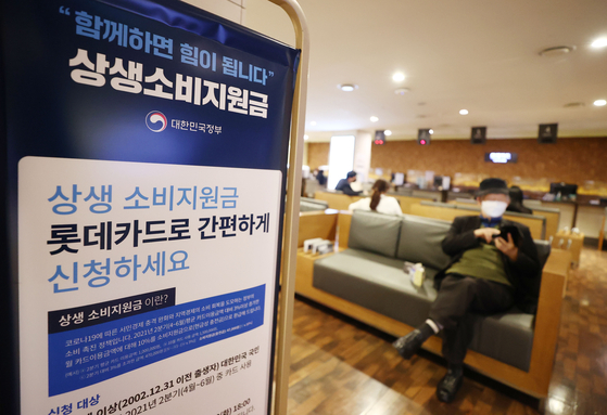 An advertisement promotes the government cash-back program at a credit card branch in Seoul in November. The government refund program was introduced to help small shop owners by encouraging people to spend. [YONHAP] 