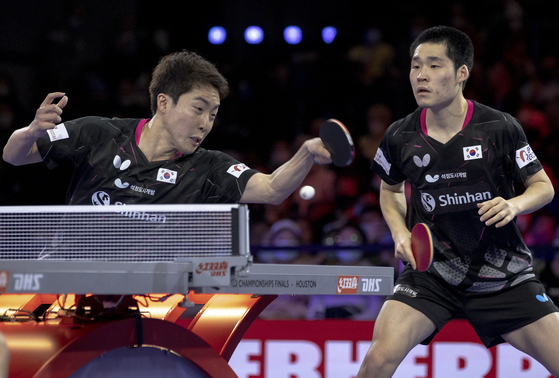 Lim Jong-hoon, left, and Jang Woo-jin compete during the men's doubles final match against Sweden's Kristian Karlsson and Mattias Falck at the 2021 World Table Tennis Championships Finals in Houston, Texas, on Monday. [XINHUA/YONHAP] 