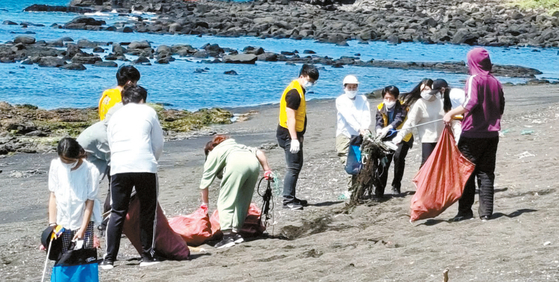 SaveJejuBada Youth club members at Korea International School of Jeju (KISJ) pick up litter at a beach on Jeju Island on April 11. [SJB YOUTH]