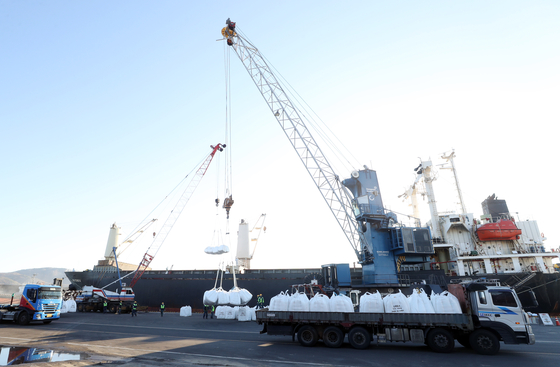Sacks of urea are unloaded from a ship at the Port of Ulsan on Thursday. A total of 3,000 tons of urea were shipped from Shandong, China, arriving in Korea on Wednesday night. [YONHAP] 