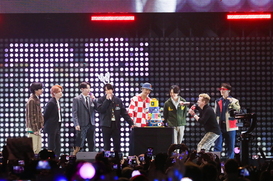 BTS members look at a birthday cake for Jin, fourth from left, on the stage at the ″Jingle Ball″ concert at The Forum in Los Angeles on Friday night.  [BIT HIT MUSIC] 
