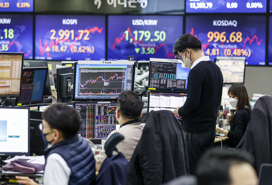 Displays at Hana Bank in Myeong-dong, central Seoul, on Tuesday show the benchmark Kospi edging closer to 3,000. The Kospi has been on a five-day rally as concerns over Omicron have been easing. The market closed 18.47 points, or 0.62 percent, higher on Tuesday. The Kospi fell below 3,000 on Nov. 23. [YONHAP]