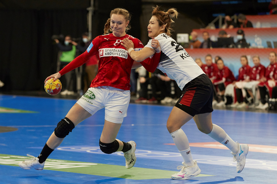 Kim On-a, right, in action against Caroline Hansen of Denmark during the preliminary round group F handball match between Korea and Denmark at the 2021 World Women's Handball Championship in Granollers, Barcelona, Spain, on Monday. [EPA/YONHAP]