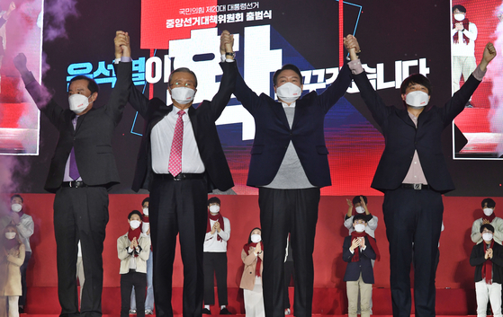 Yoon Suk-yeol, second from left, presidential candidate of the opposition People Power Party (PPP), cheers at the launch of the PPP election campaign committee at the KSPO Dome at the Olympic Park in Songpa District, eastern Seoul, on Monday, alongside the campaign’s general chairman Kim Chong-in and party chief Lee Jun-seok. [JOINT PRESS CORPS]