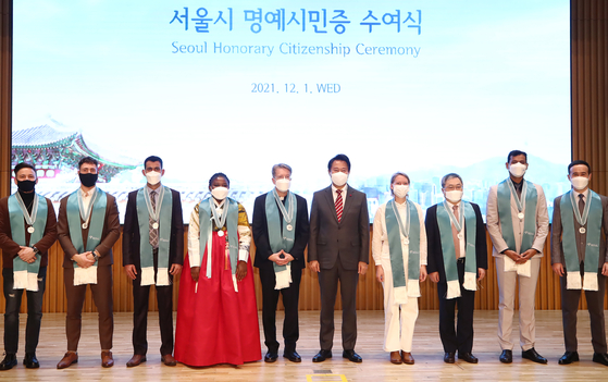 Nine foreign nationals, including Justin John Harvey, fifth from left, pose with Seoul mayor Oh Se-hoon after receiving honorary citizenships at the 2021 Seoul Honorary Citizenship Ceremony in Seoul City Hall, central Seoul, Wednesday. [YONHAP]