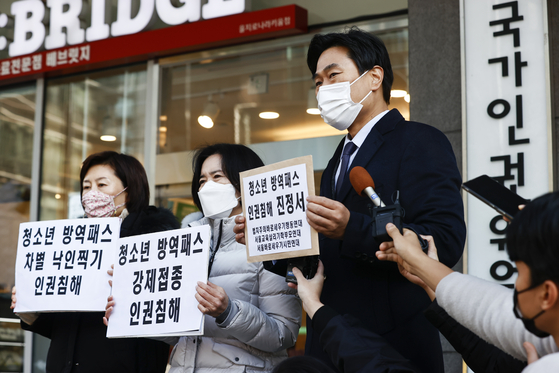 Members of civic groups protest the implementation of vaccine passes for teenagers, saying it is a violation of the students’ rights, during a press conference in front of the National Human Rights Commission of Korea's office in Jung District, central Seoul, after submitting their petition to the commission Wednesday. [YONHAP]