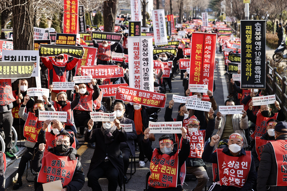 A group of small business owners protest near the National Assembly building in Yeongdeungpo District, western Seoul, on Wednesday. The participants, including 20 business owner committees such as the Korea Foodservice Industry Association, requested the government properly compensate them for losses during the pandemic and lift restrictions on gathering. [YONHAP] 