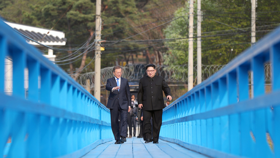 South Korean President Moon Jae-in, left, and North Korean leader Kim Jong-un stroll across a footbridge during their summit on April 27, 2018, at the inter-Korean truce village of Panmonjom. [YONHAP]