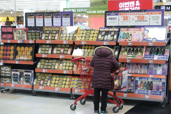 A visitor shops for New Year gift sets at a discount mart in Seoul on Thursday. The National Assembly's Legislation & Judiciary Committee on Wednesday passed a bill that temporarily eases the anti-graft law for the upcoming Lunar New Year holiday. With the bill, public servants, educators and journalists will be allowed to receive gifts of up to 200,000 won ($170). They can only receive gifts worth less than 100,000 won under the current law. [YONHAP]