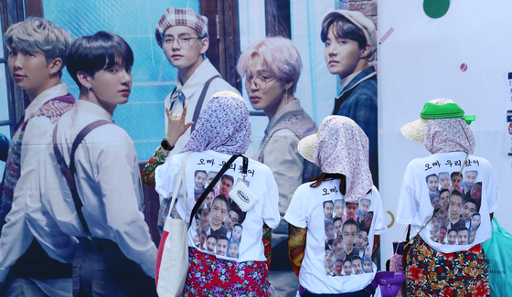 Fans of BTS, dubbed ARMY, wear t-shirts that have "Oppa, we're here" written on the back at the boy band's fan meet "2019 BTS 5th Muster: Magic Shop" held in Songpa District, southern Seoul, on June 22, 2019. [ILGAN SPORTS]