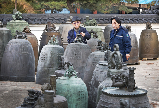 Won Kwang-sik discusses restoring traditional Korean temple bells with his son Chun-soo. [PARK SANG-MOON]