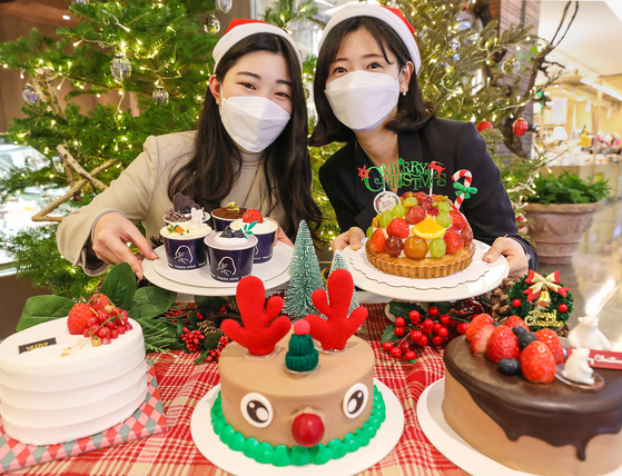 Models promote Christmas cakes that can be reserved for purchase at Hyundai Department Store branches that started Sunday. [HYUNDAI DEPARTMENT STORE]